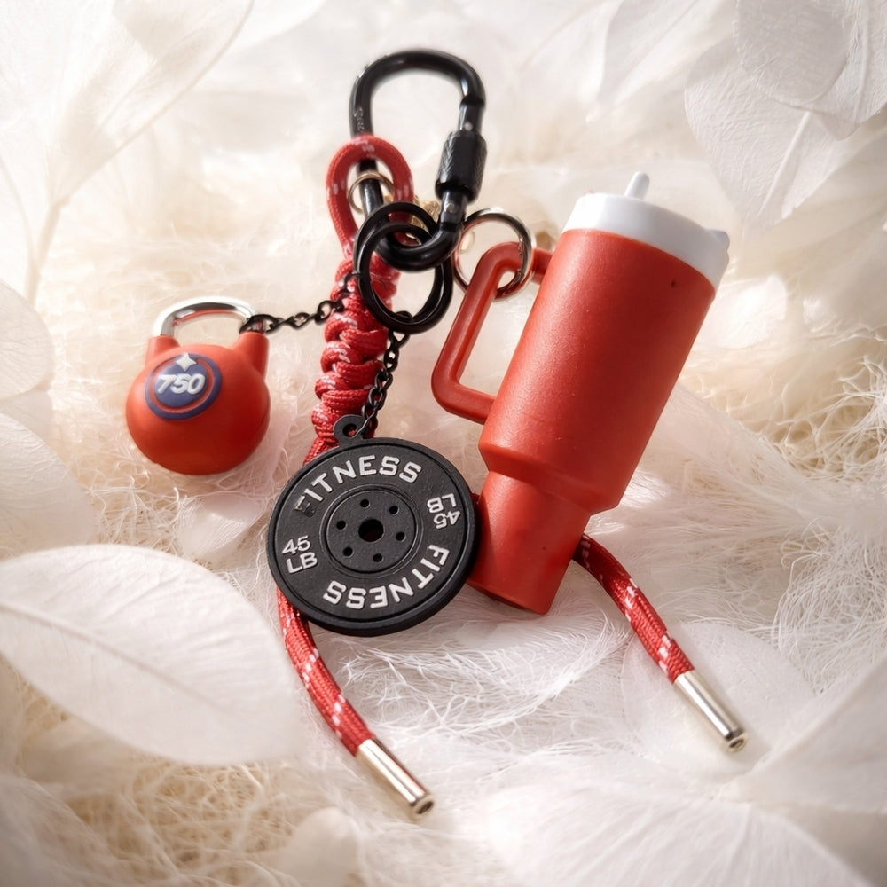 Black fitness charm keychain with tumbler, kettlebell, and dumbbell charms on black paracord